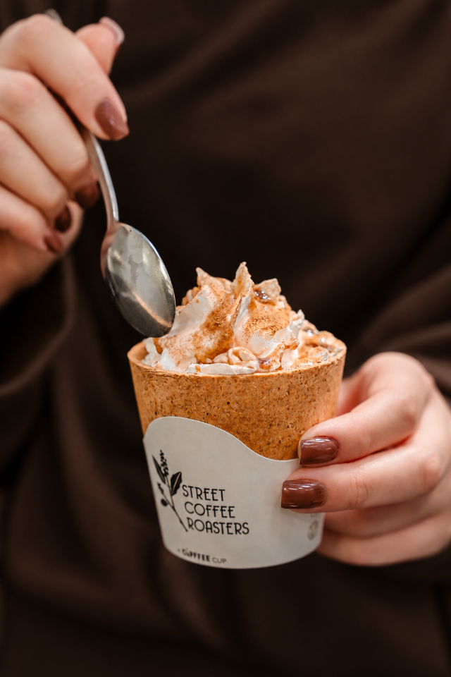 O băutură cremoasă într-un pahar Street Coffee
